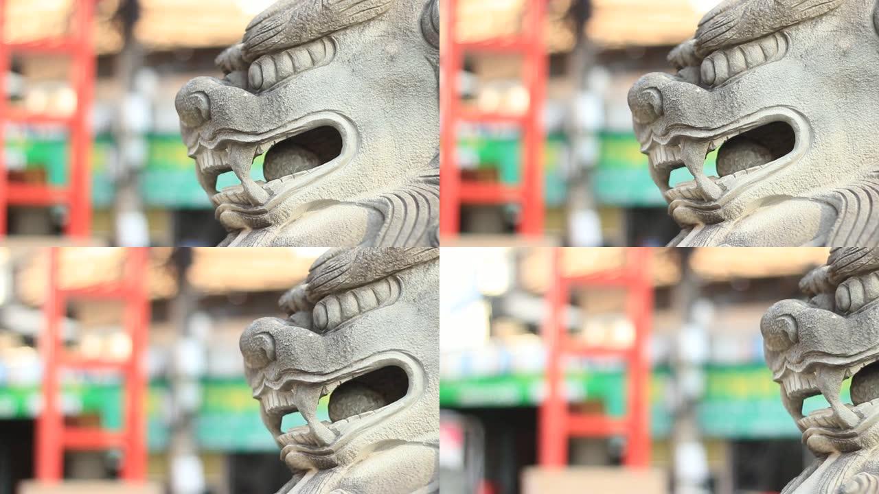 平移显示的镜头显示，在东南亚中国城镇地区的门口，传统的中国狮子站岗