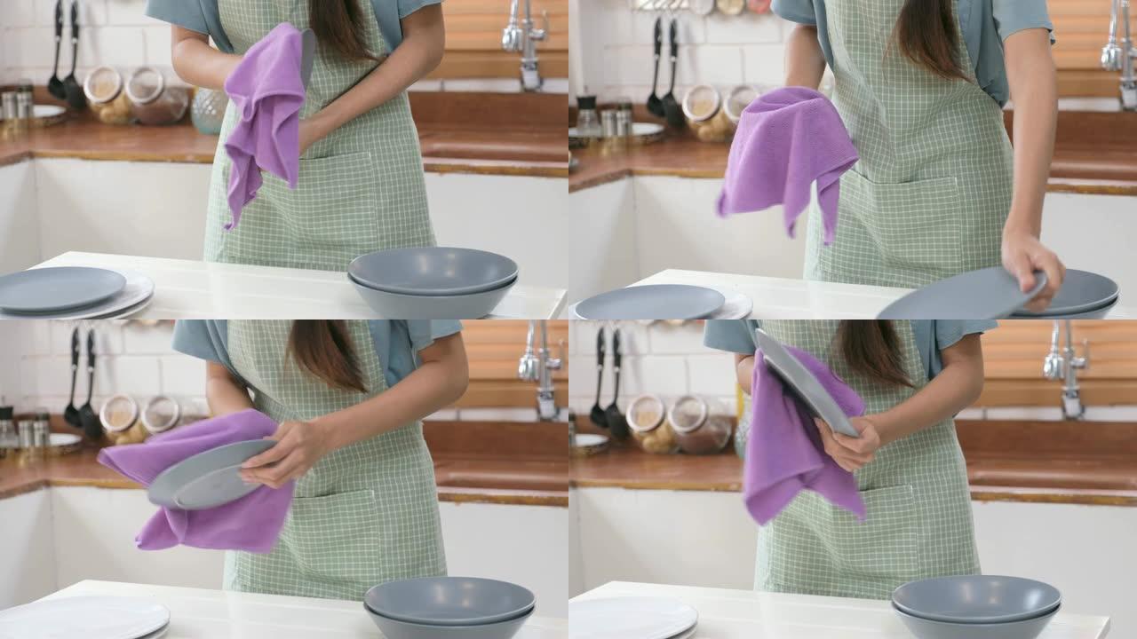 女性在家庭厨房用洗碗巾手清洁餐具，生活方式