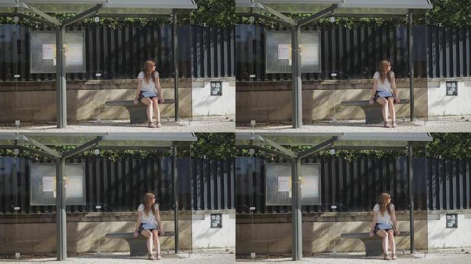孤独的年轻女孩穿着裙子在公共汽车站等着，夏天