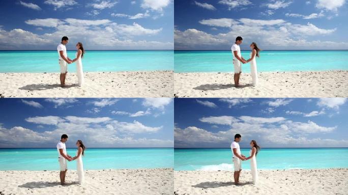年轻美丽的新婚夫妇在海滩上宣誓效忠