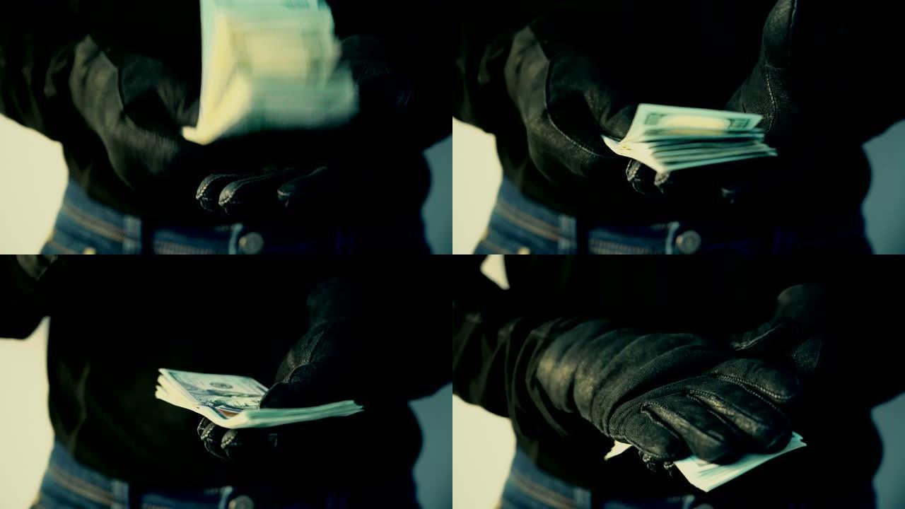 戴着黑手套的男人拿着一堆钱，犯罪概念