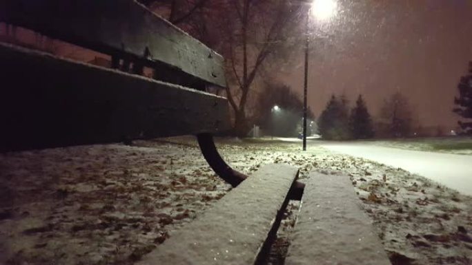 从长凳上可以看到公园里下雪的夜晚