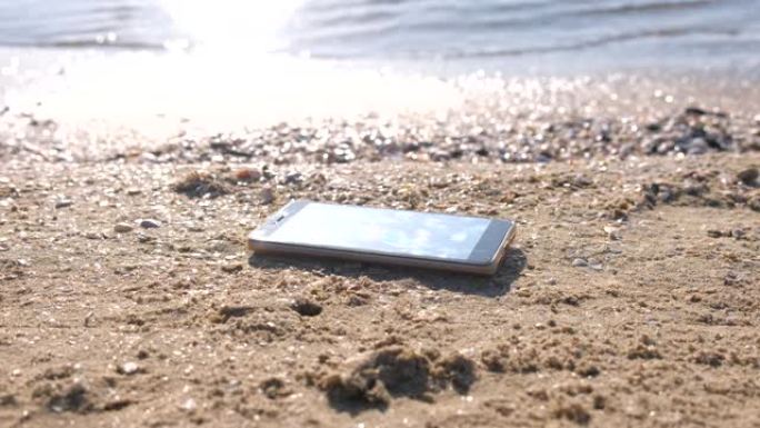 手机在沙滩上海浪。