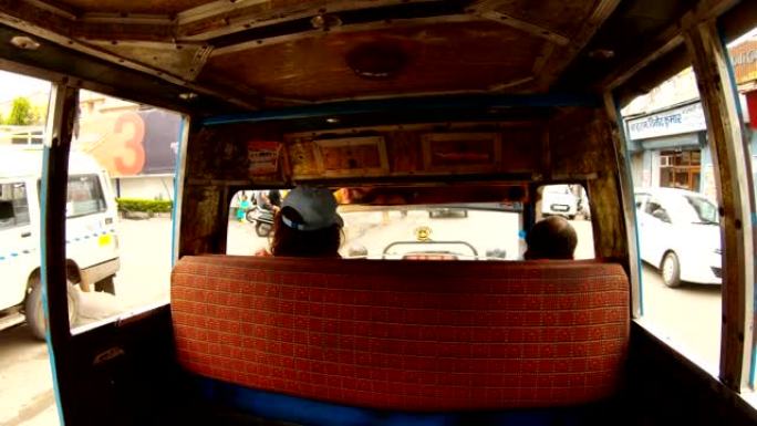 印度男子从前排座位的中间驾驶自动人力车白色前排座位街，坐在司机和乘客身上