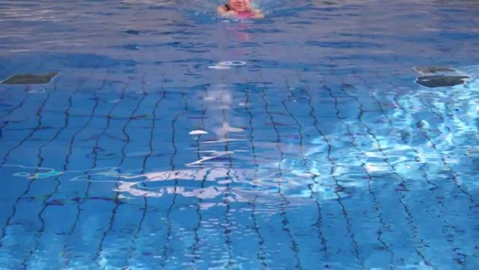 在游泳池里用踢脚板游泳的日本女孩