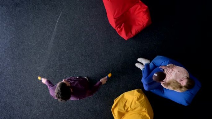 男子跳绳和女子玩球坐在彩色软包上的最佳镜头。