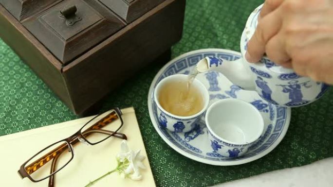 桌上放着玻璃杯、书籍和木箱的中国茶