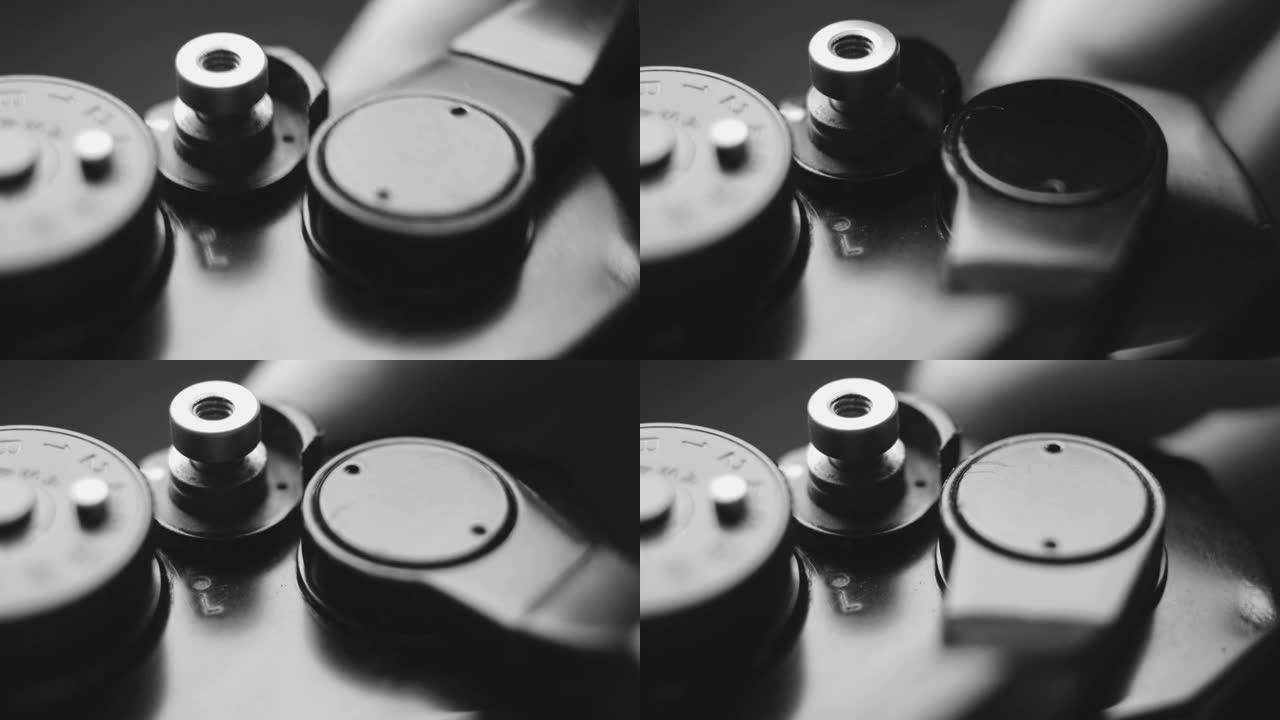 旧的老式单反胶片相机和快门释放按钮的特写细节，同时手指调整相机并按下快门释放按钮