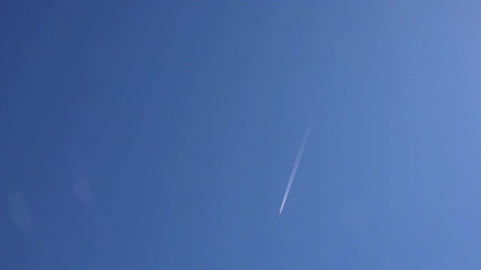 飞行的飞机在蓝天下留下白线。4K
