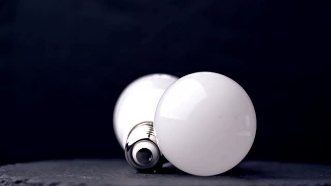 客厅照明电灯发光二极管和白炽灯泡特写躺在桌子上
