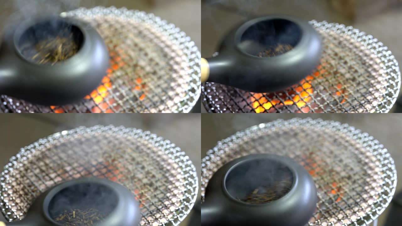 用陶器烤盘在土木炭火盆上烤绿茶。烤绿茶在日语中称为Hojicha。