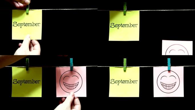 两个彩色贴纸。左边有一张纸上写着“九月”。右边白色的床单表达了节日的气氛。黑色背景。