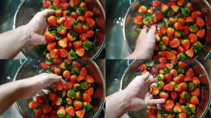 红色，成熟的草莓在水槽中洗净，水溅满了闪亮的水滴，看起来非常新鲜和干净