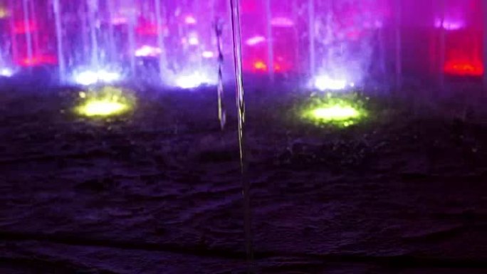 喷泉水的特写镜头具有清澈的水线和带有变色led灯的喷射