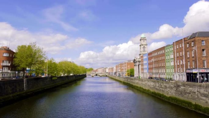 在都柏林的夏日，交通和人员在桥上移动。利菲河和爱尔兰都柏林的四个法院大楼。