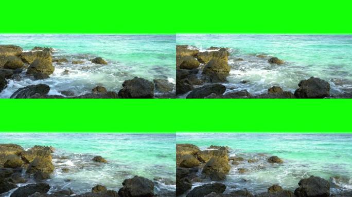 4k视频景观，在夏季阳光下，绿屏色度关键背景下，清晰的绿松石蓝色海浪溅到岩石上。
