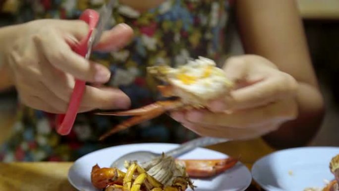 亚洲女人吃螃蟹海鲜烧烤烧烤。