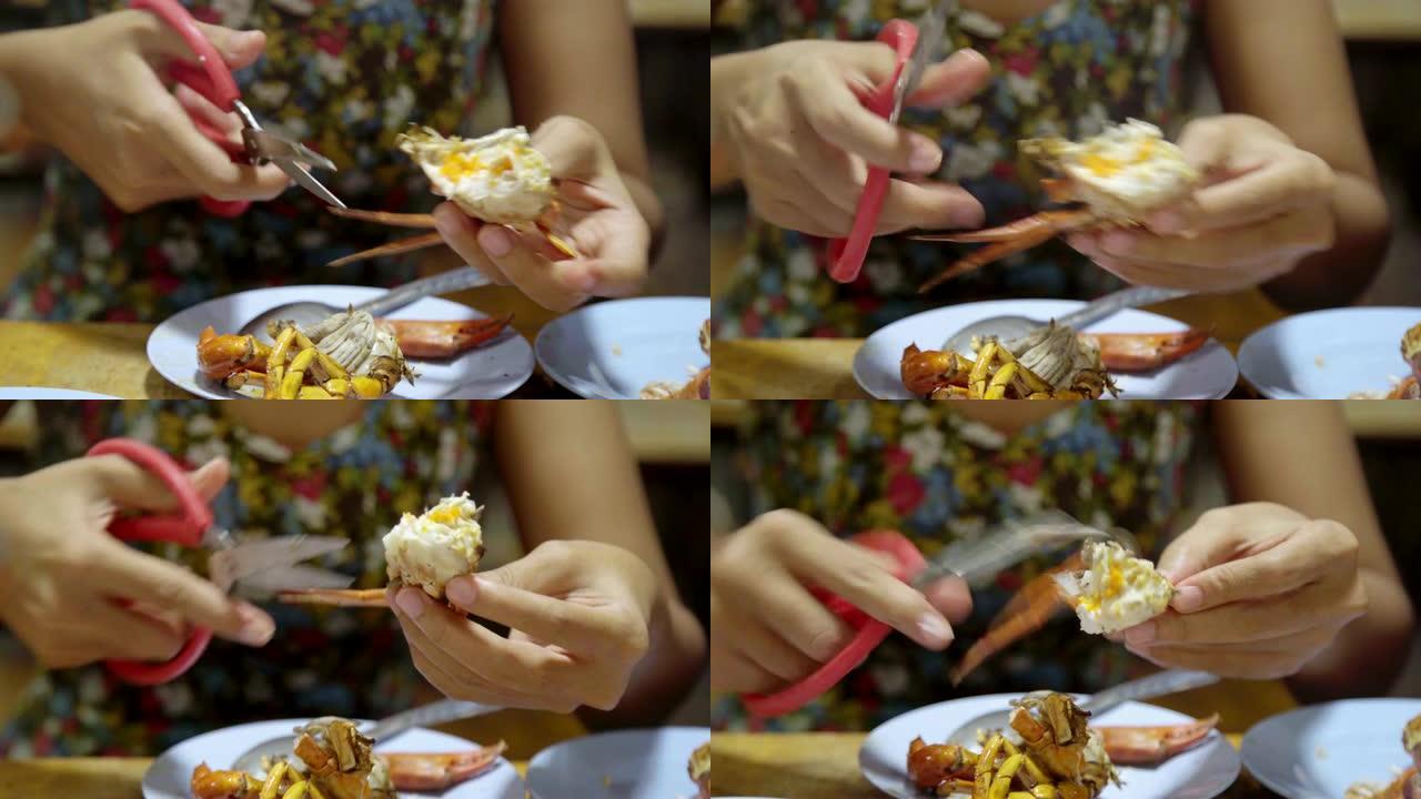 亚洲女人吃螃蟹海鲜烧烤烧烤。