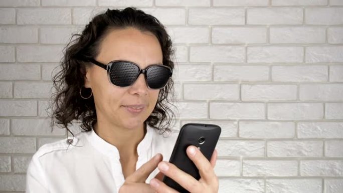 女人用针孔眼镜在智能手机上打字。