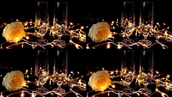 明亮的花环背景下的香槟和玫瑰眼镜。