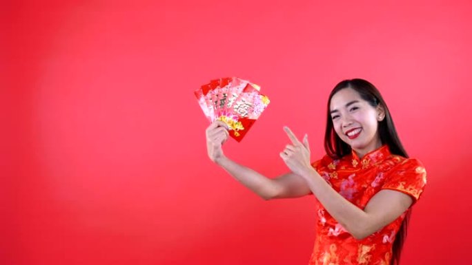 穿着旗袍中国连衣裙的女人拿着红色的钱口袋