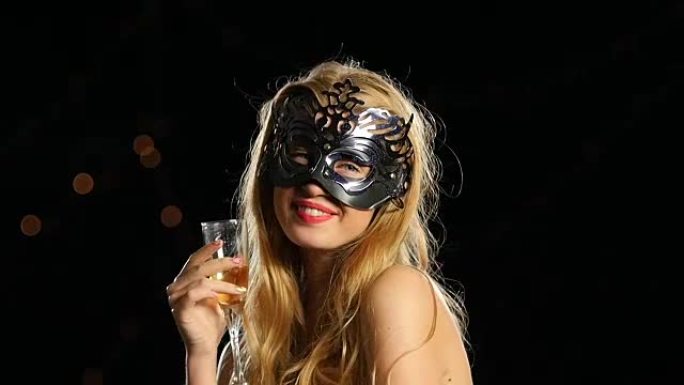 戴着威尼斯面具和一杯香槟的非常性感的女人。慢动作。特写