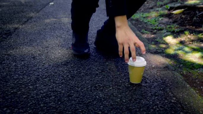 Slowmo-乱扔垃圾的概念-穿着西装的匿名亚洲男子在地板上放下外卖咖啡杯