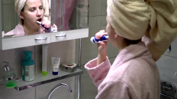 女人用电动牙刷刷牙