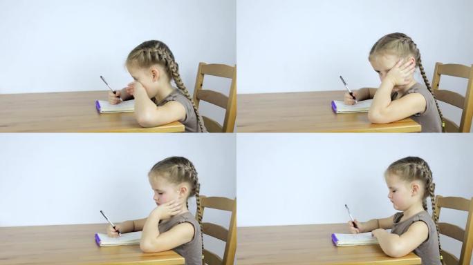 小女孩在笔记本上学习和写作业