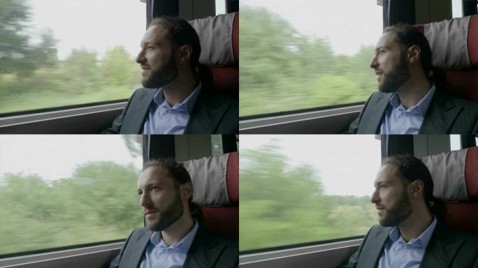 穿着西装的快乐白日梦男子坐火车透过窗户欣赏风景