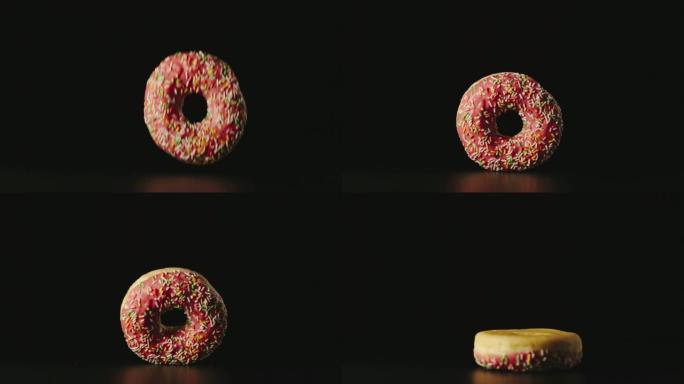 慢动作: 粉红色的甜甜圈落在桌子的黑色表面上，站在一边