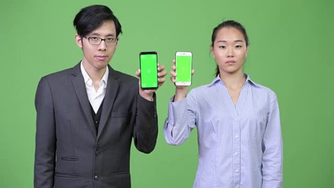 年轻的亚洲商业夫妇一起展示电话