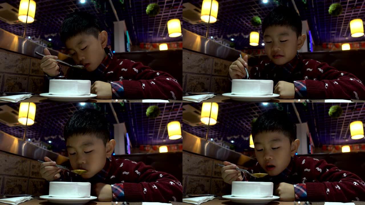 亚洲男孩在西餐厅喝汤