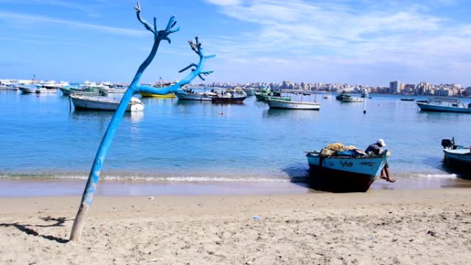 埃及亚历山大港蓝色地中海渔船的景色。亚历山大海滩的景色，地平线上有很多渔船，在阳光下。