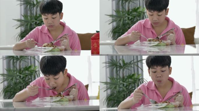 4k亚洲男孩在家吃午餐，午餐吃食物，带茉莉花饭盒的饭盒。