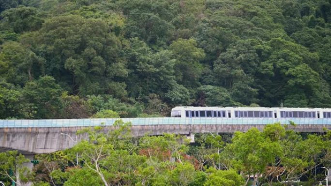 4k大众捷运 (MRT) 列车以绿色森林背景在轨道上行驶