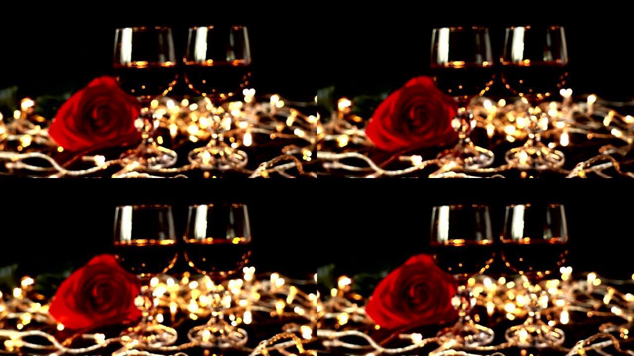 在明亮的花环的背景下，酒杯和玫瑰。注意力不集中。