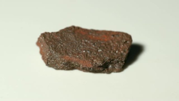 旋转白色背景的橄榄石赤铁矿矿物样品