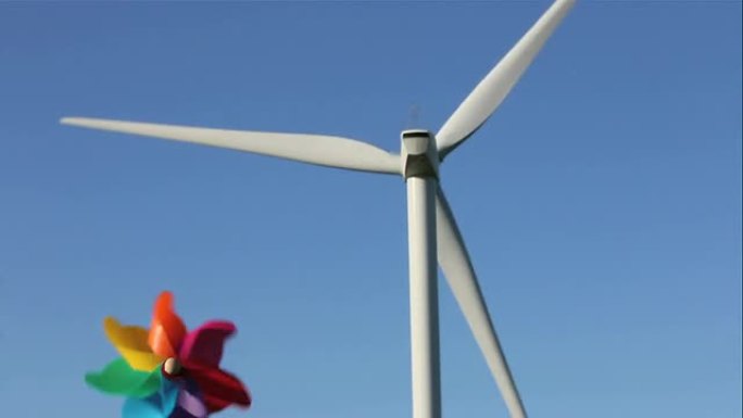 风力涡轮机和儿童风车对抗蓝天