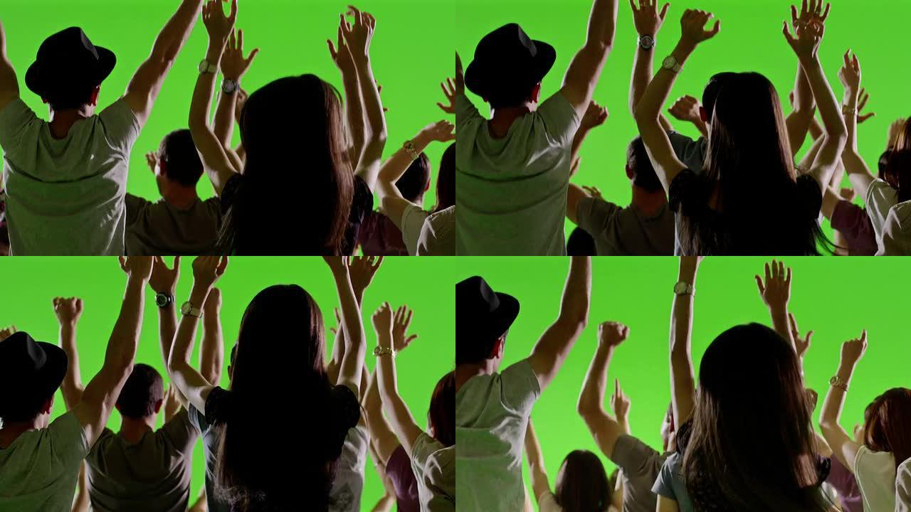一群粉丝在绿屏上跳舞。音乐会，跳跃，跳舞。慢动作。在红色史诗电影相机上拍摄。