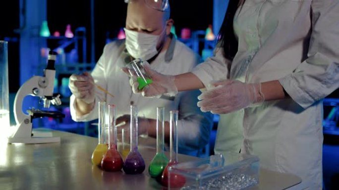 在化学实验室中进行液体分析的实验。移液器被收集到溶液中，并在显微镜反应下观察。