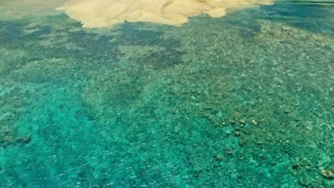 令人惊叹的空中无人机图像，大珊瑚礁在平静的天气平坦的海水和令人难以置信的五颜六色的海洋床中遇到沙滩，
