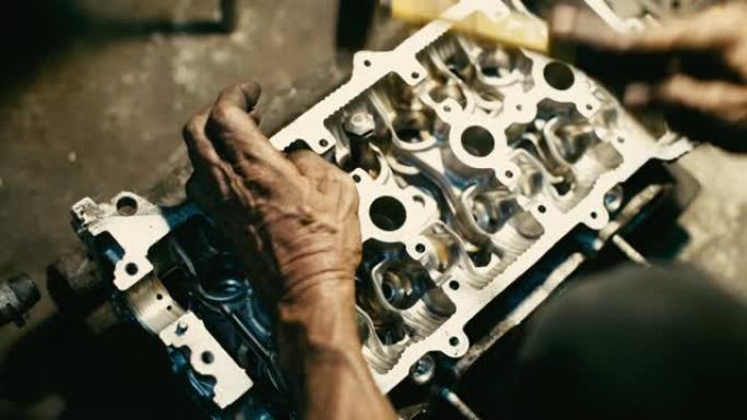 工人机械师在车库车间准备和钻孔用于固定气门头发动机的核心活塞或柱塞。