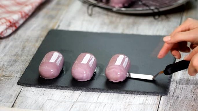 紫色慕斯蛋糕配蓝莓。釉面甜点的生产。