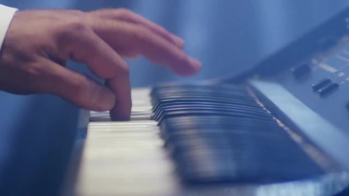 男人演奏音乐键盘。音乐家弹钢琴。在红色史诗电影相机上拍摄。