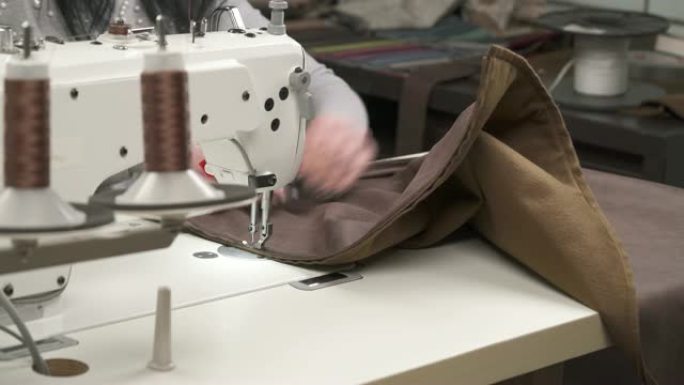 用生产线上的缝纫机缝制皮革元素的侧视图。