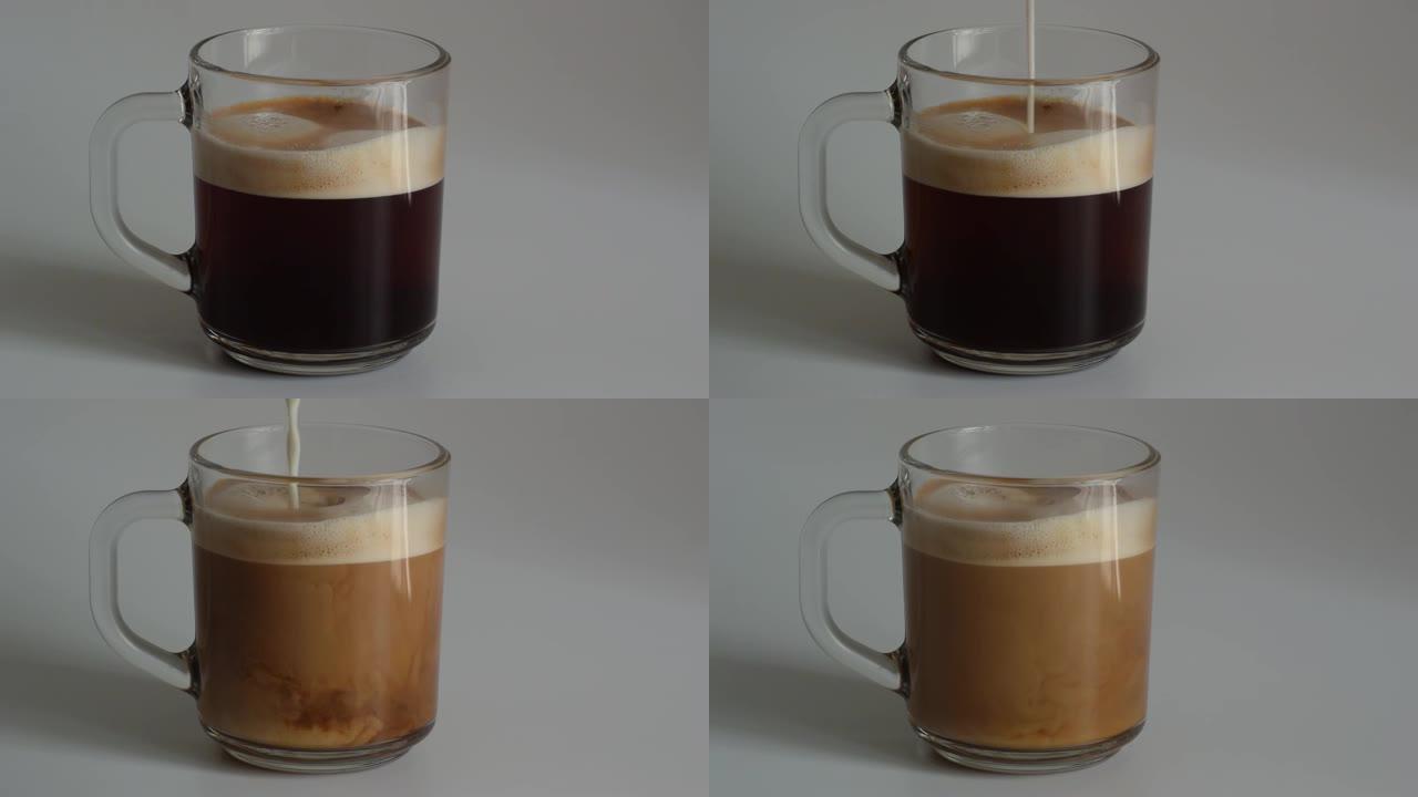 将牛奶添加到装有新鲜芬芳的黑咖啡和泡沫奶油的玻璃杯中的特写镜头