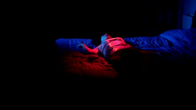 沮丧悲伤的年轻女子晚上独自躺在床上
