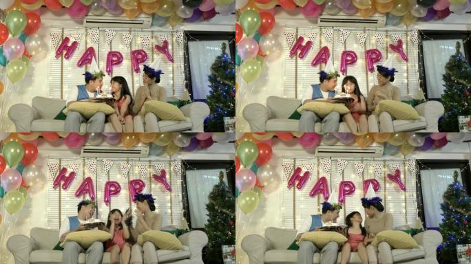 父亲和母亲一起在生日聚会上给女儿拿着蛋糕。在家的家庭时光快乐。节日、新年和圣诞节的概念。4k分辨率。