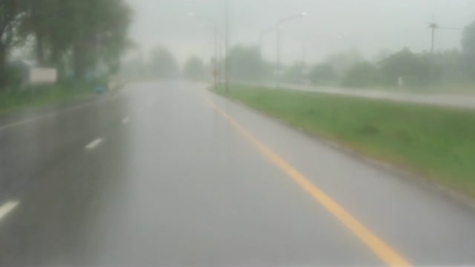 POV，公路旅行在雨中缓慢驾驶汽车通过挡风玻璃，雨刷正在清除雨水。在湿滑的高速公路上开车。4k视频片